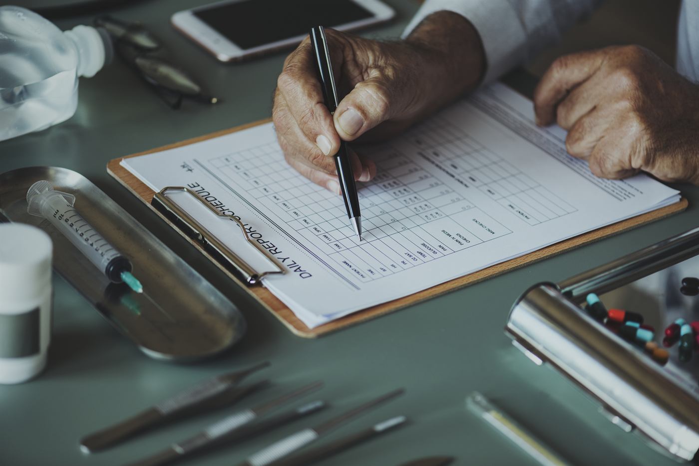 A clinician recording notes on a checklist