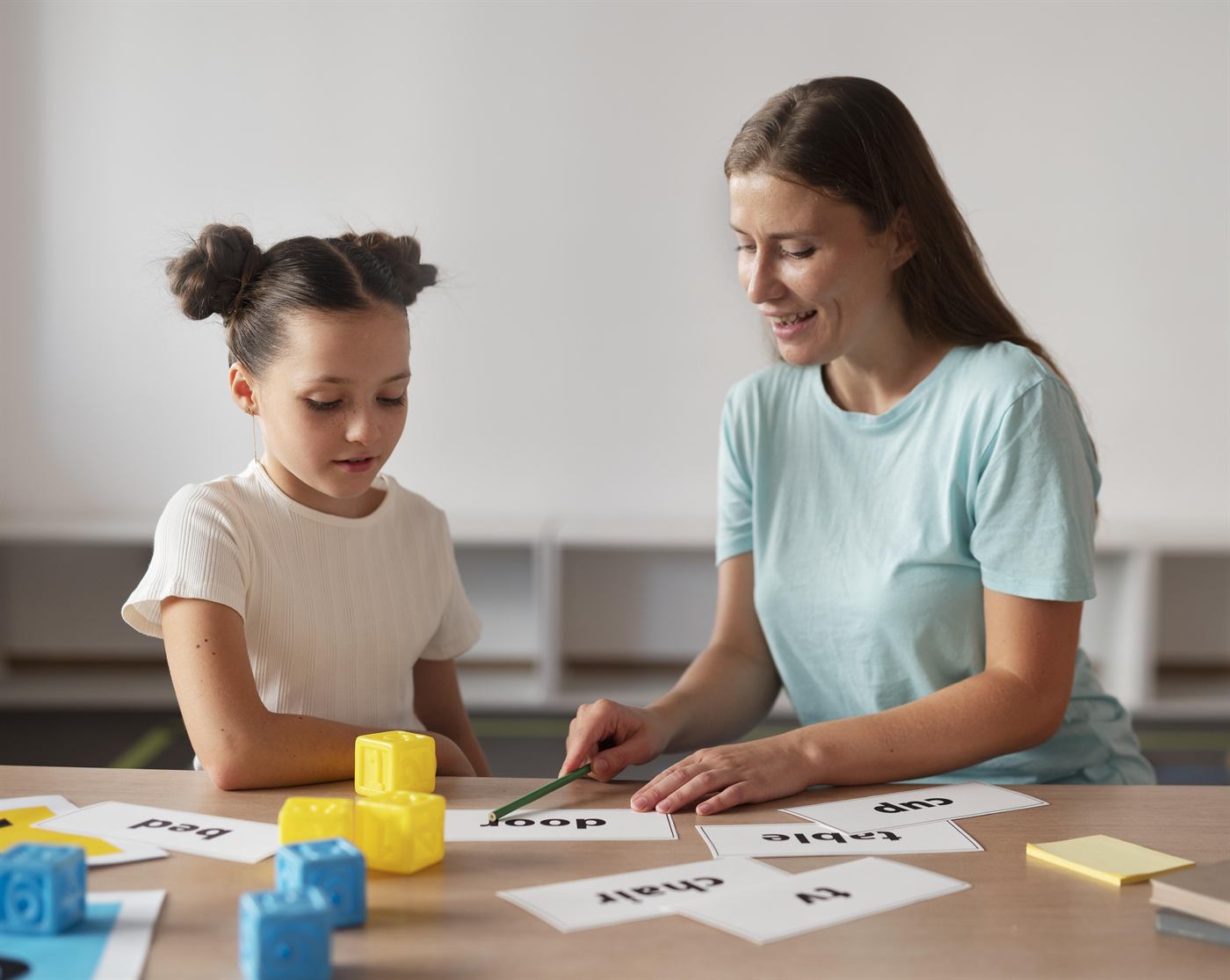 A therapist working with a young girl at a table