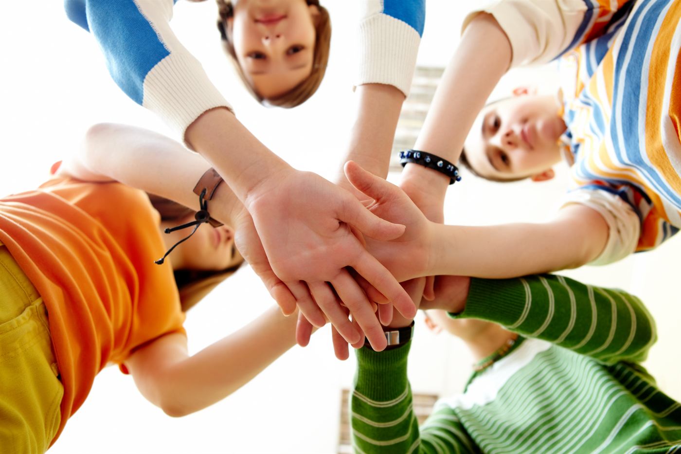 Children stacking their hands together in a circle