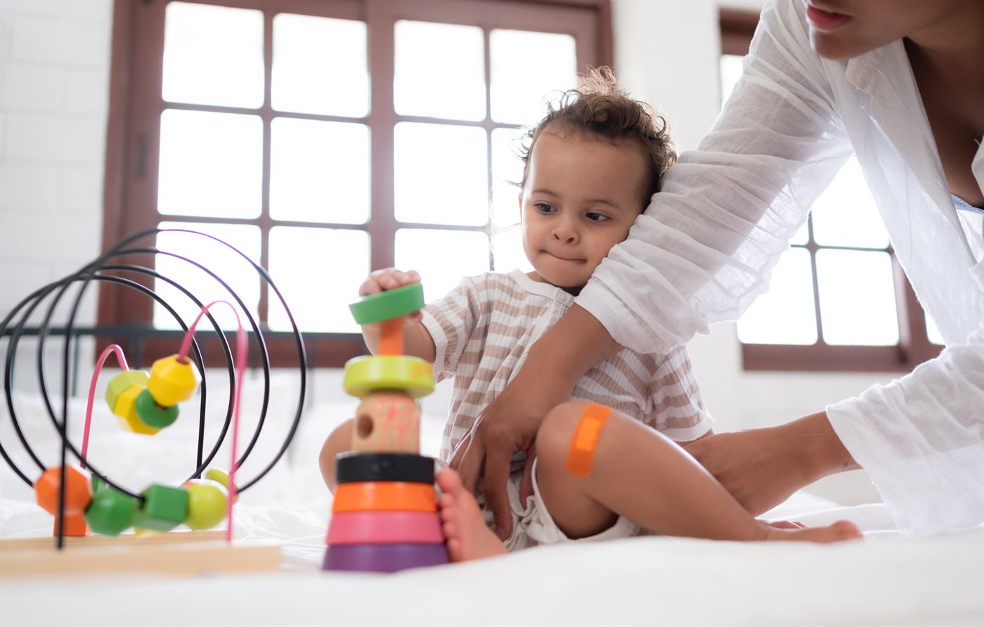A mother and little girl playing with toys at home