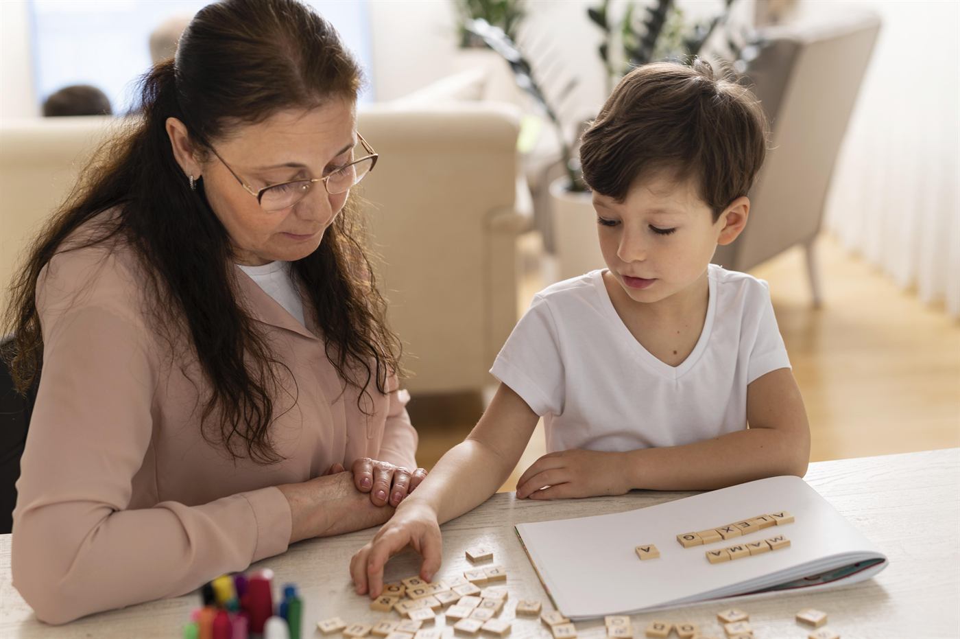 A grandmother helping a child with homework at the table