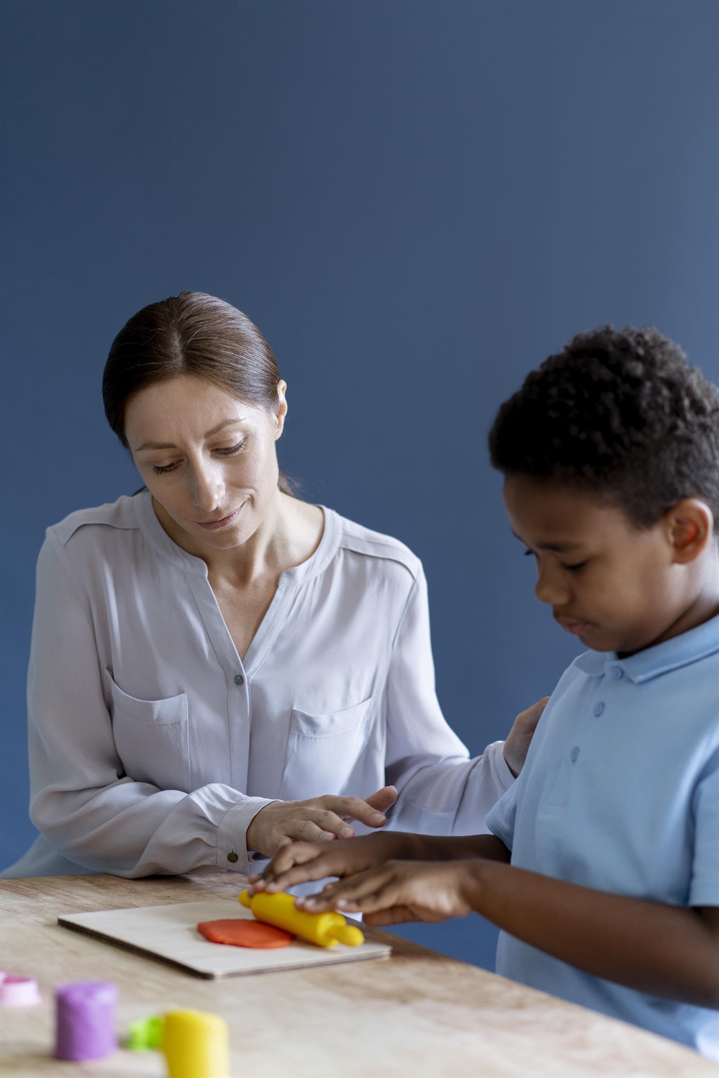 A clinician working with a child at a table